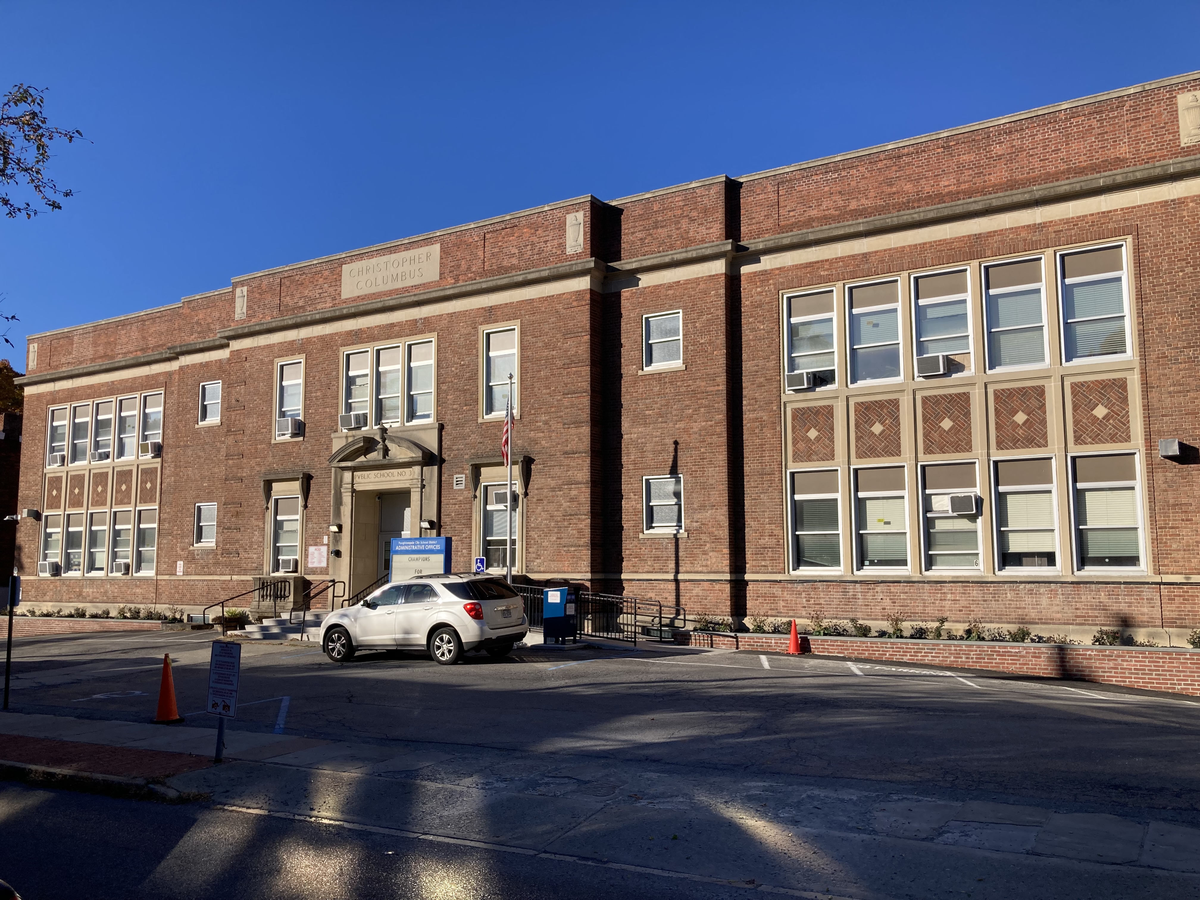A group of people pose in front of a colorful backdrop with balloons.